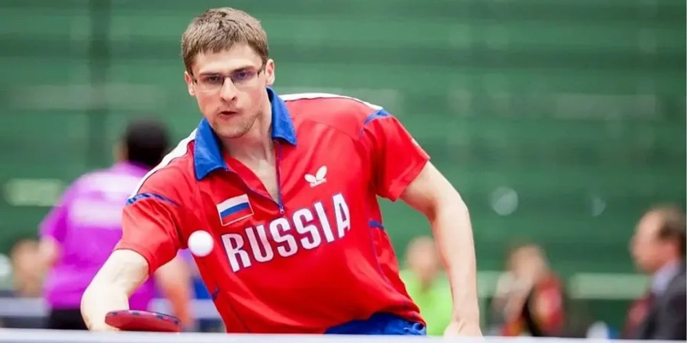 Спортсмени за столом для настільного тенісу під час міжнародних змагань