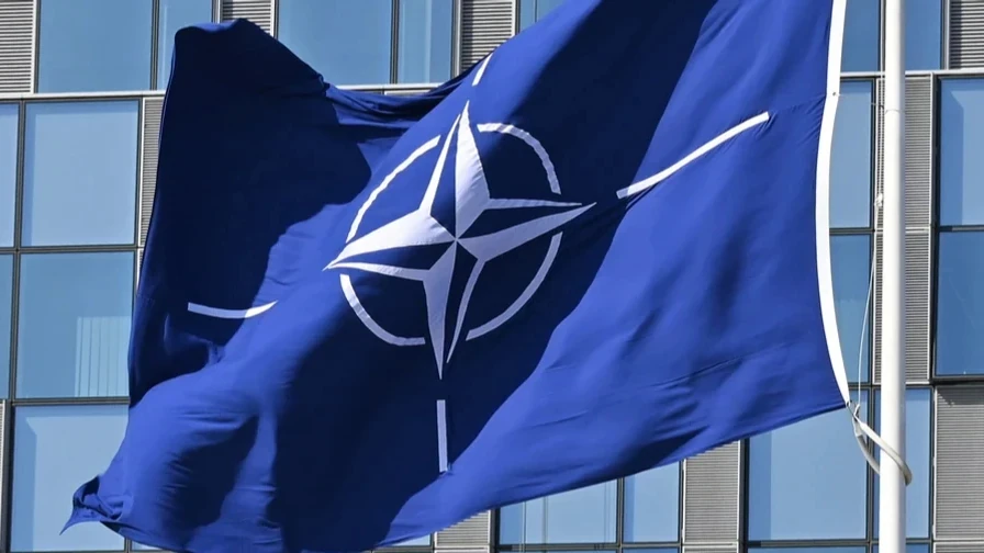 Прапор НАТО на тлі будівлі штаб-квартири альянсу